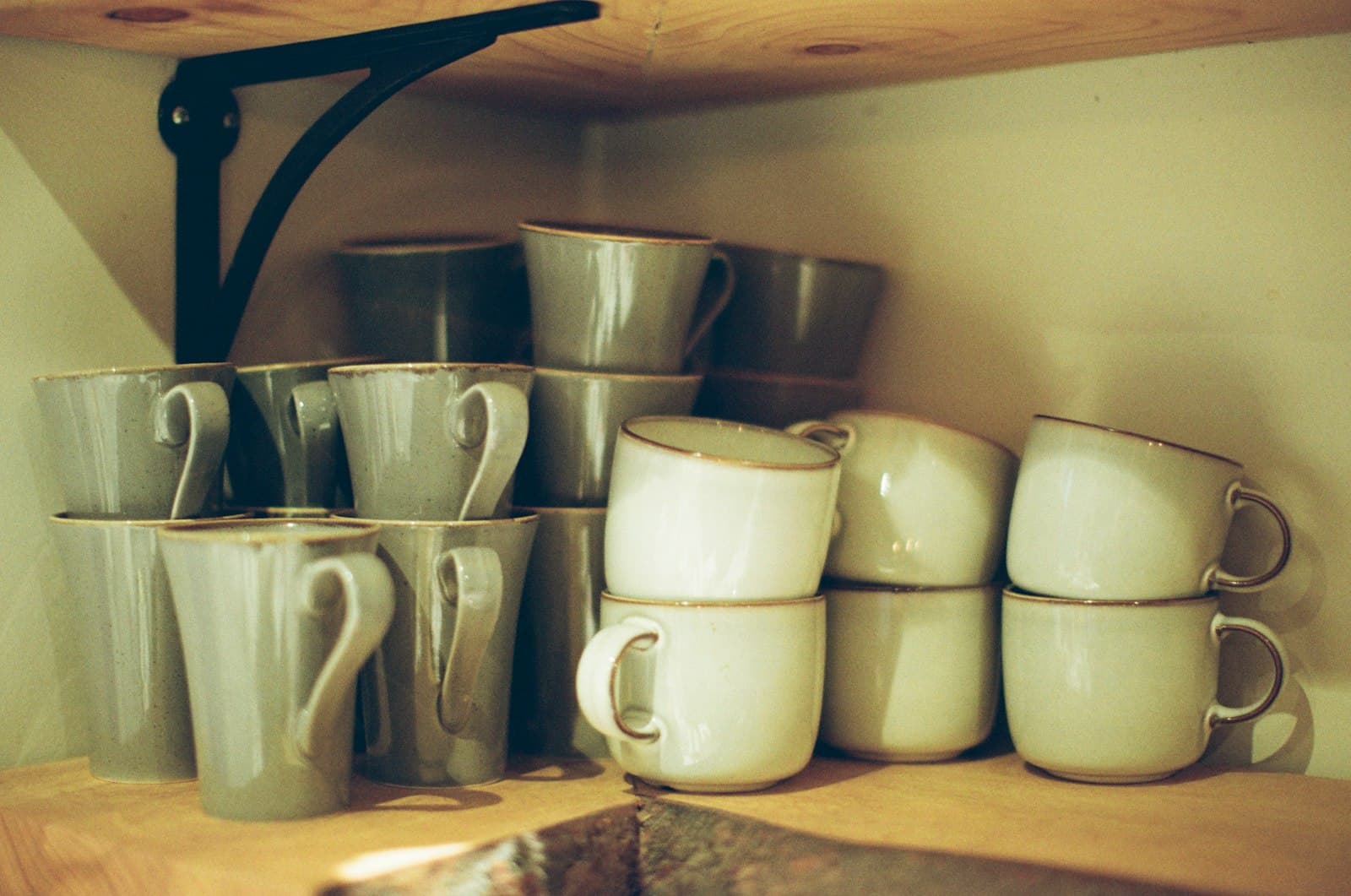 A minimal stack of ceramic mugs and pitchers on a shelf