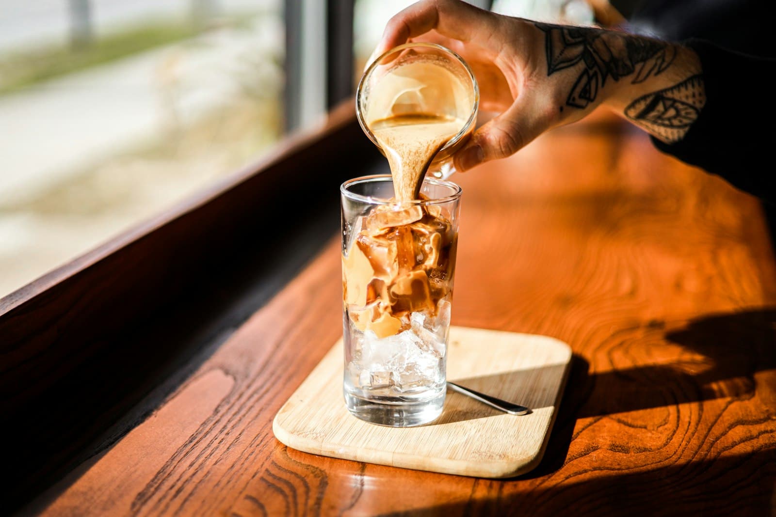 A glass of iced coffee packed with ice cubes