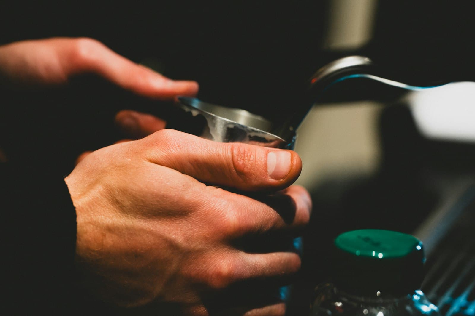 A barista tamping coffee grounds into a portafilter