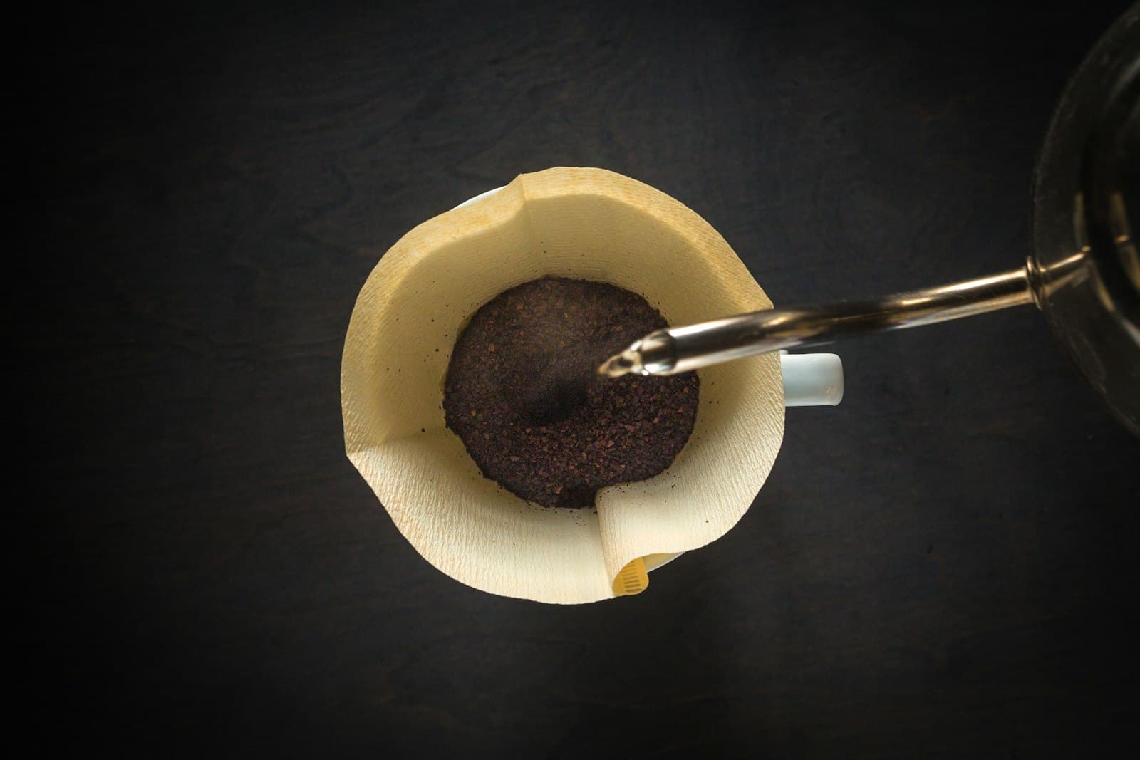 Water being poured over a pour-over cone set on a brown mug