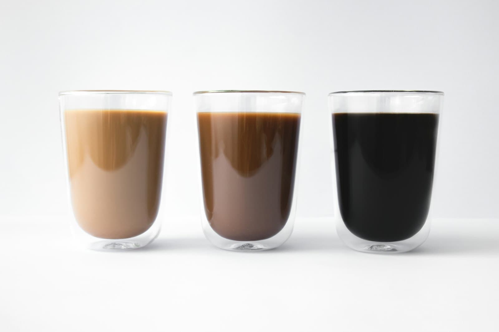 Two double-walled glasses filled with layered iced coffee