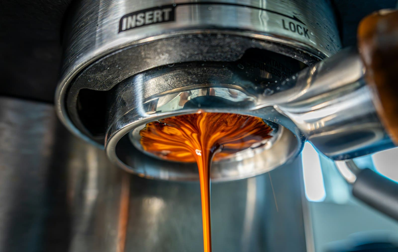 Espresso flowing from a portafilter into a cup