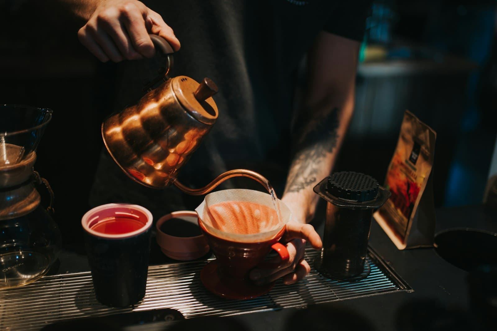 Fresh coffee being poured into a brown ceramic mug