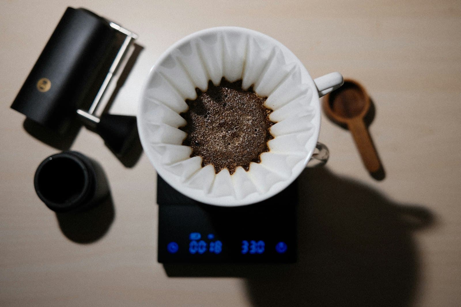 A cup of coffee brewing on a digital scale with timer