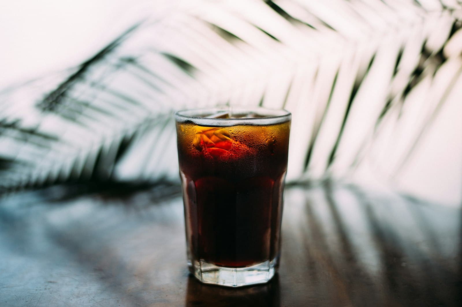 A glass of pale, lightly brewed coffee on a table